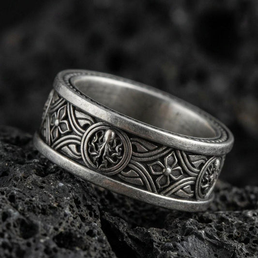 Oxidized sterling silver spinner ring on volcanic stone, macro close-up highlighting the Celtic knotwork band, raised medallion details, and antique shadow contrast.