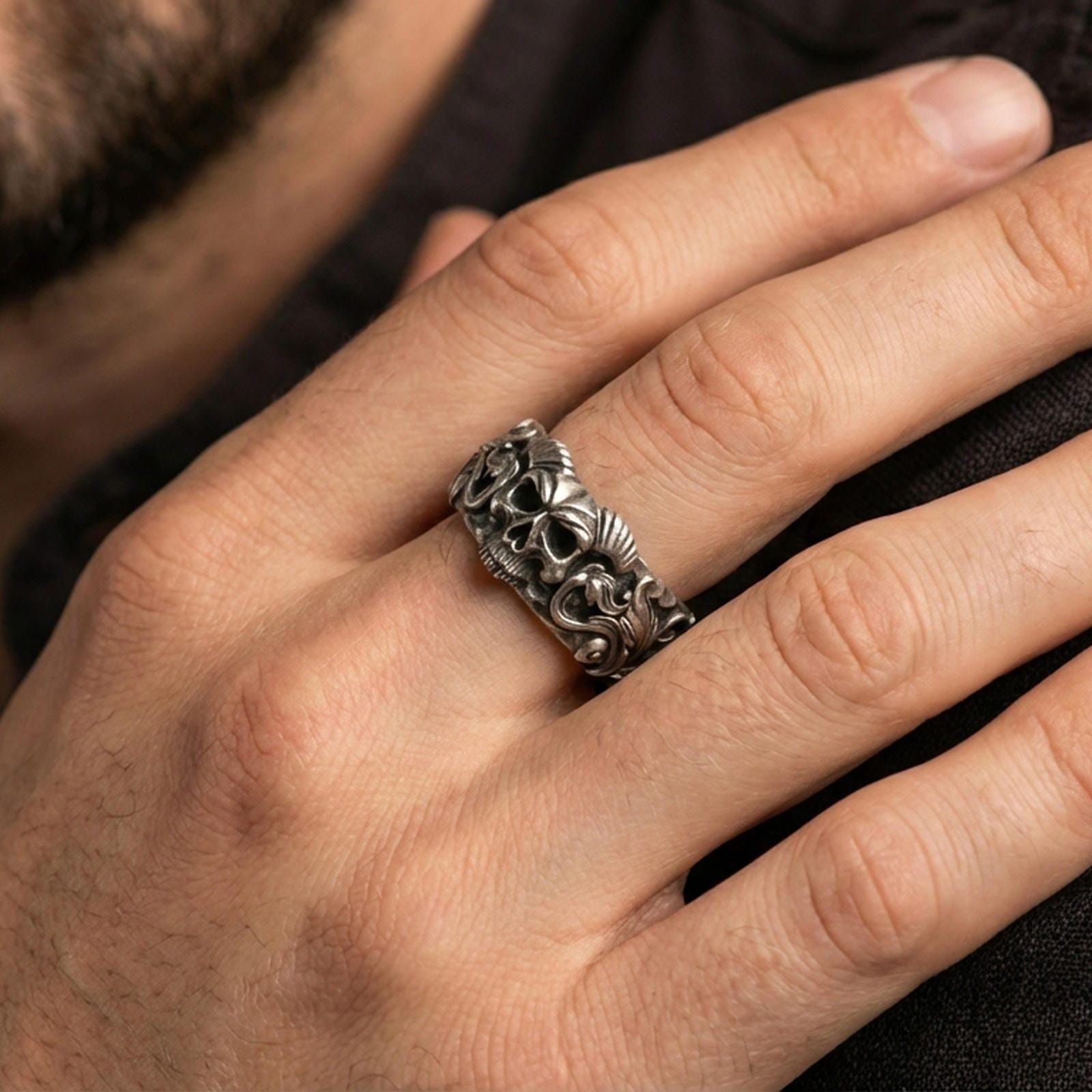 Oxidized sterling silver skull ring worn on the finger, lifestyle image focusing on bold gothic statement presence, antique depth, and rugged styling.