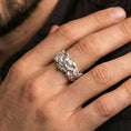 Load image into Gallery viewer, Polished silver skull ring worn on the finger, lifestyle shot highlighting bright metallic finish, sharp skull definition, and everyday statement wear.
