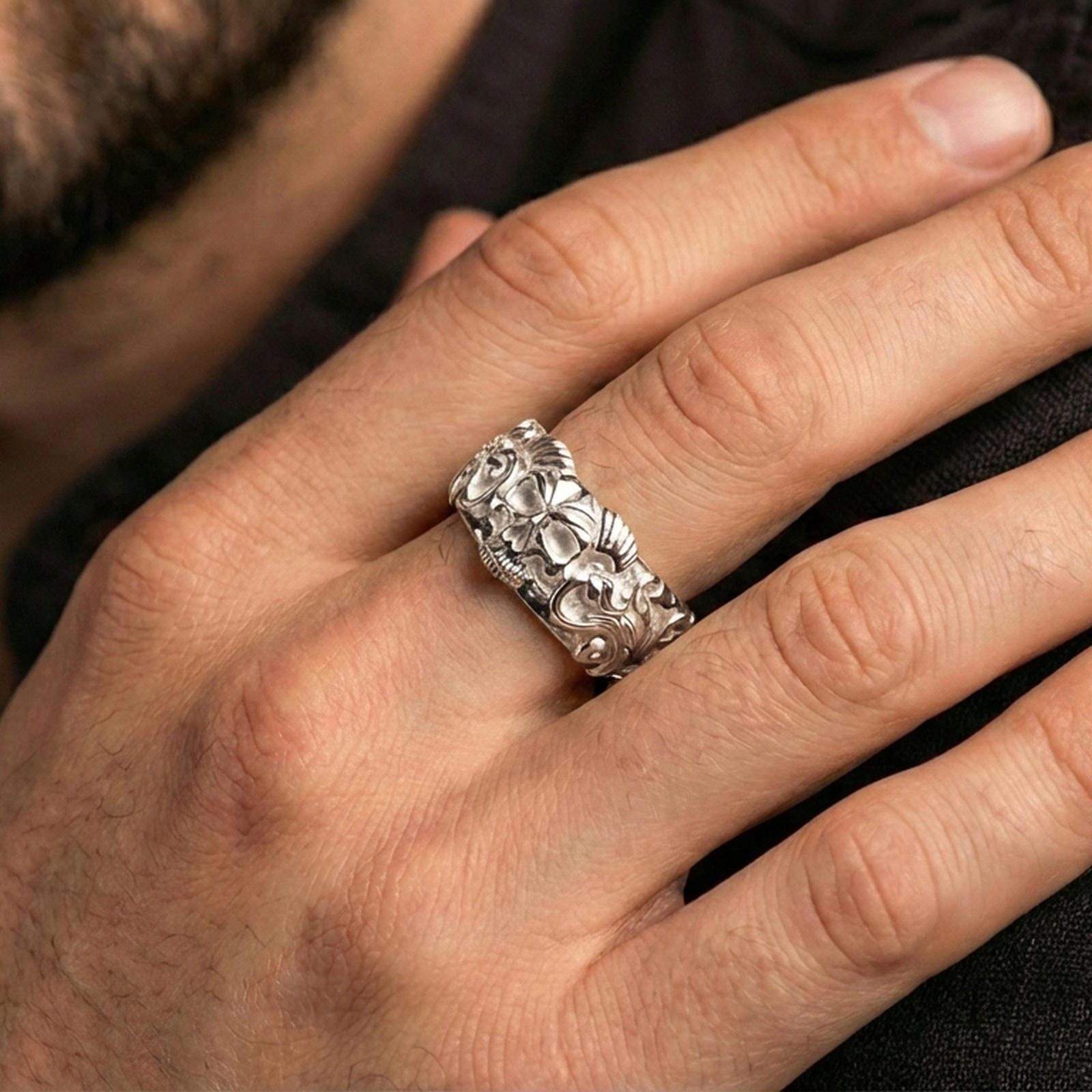 Polished silver skull ring worn on the finger, lifestyle shot highlighting bright metallic finish, sharp skull definition, and everyday statement wear.