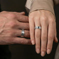 Load image into Gallery viewer, Polished silver pebble texture band ring worn on the finger, lifestyle shot highlighting modern clean look, reflective finish, and tactile textured band profile.
