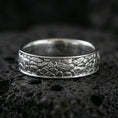 Load image into Gallery viewer, Polished silver pebble texture band ring on volcanic stone, crisp macro photo emphasizing bright shine, smooth edges, and textured surface detail.
