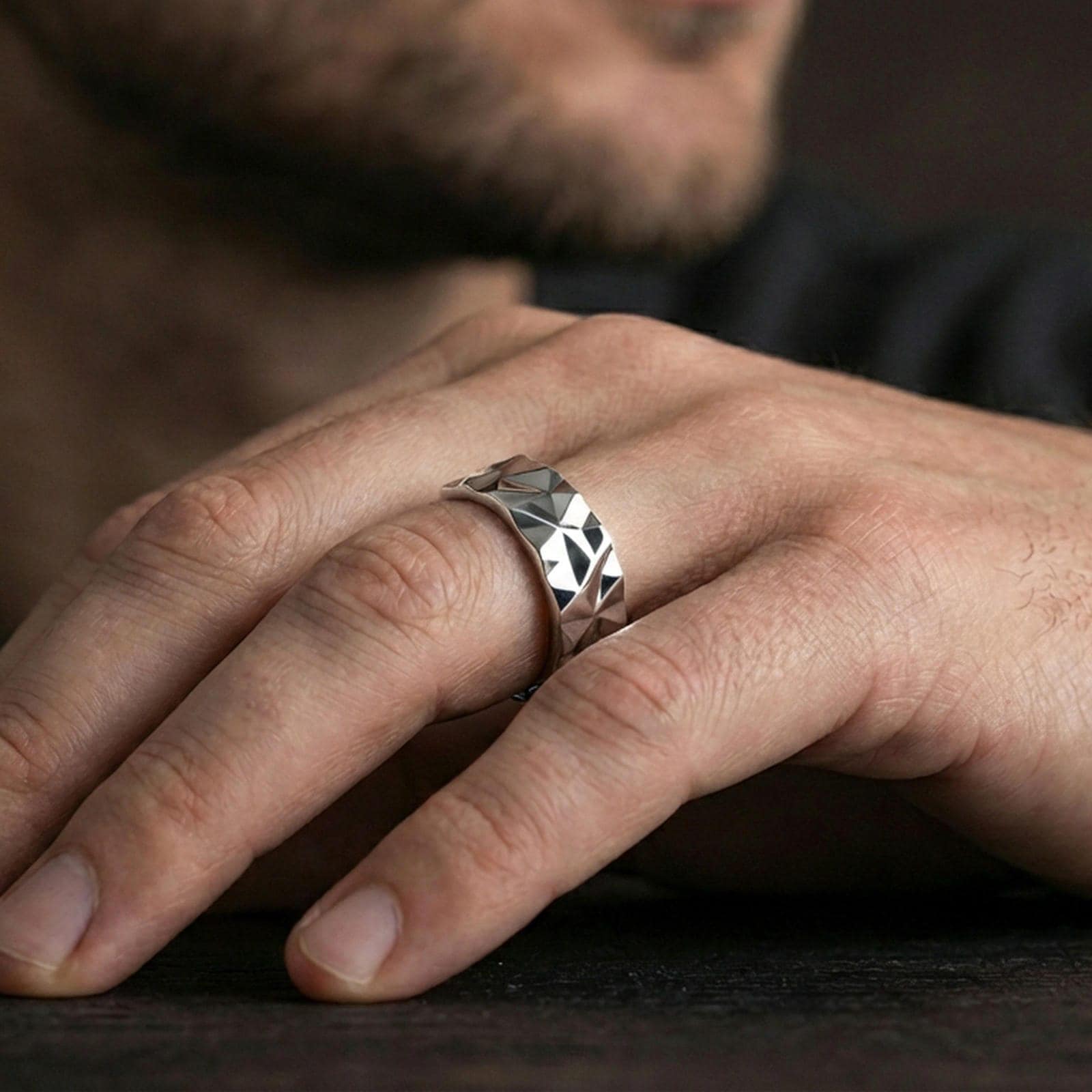 Polished silver faceted geometric band ring worn on the finger, lifestyle shot highlighting sleek minimal style, sharp facets, and everyday wear versatility.
