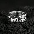 Load image into Gallery viewer, Polished silver faceted geometric band ring on volcanic stone, crisp macro shot emphasizing clean reflections, angular texture, and modern minimal form.
