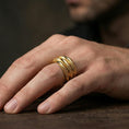 Load image into Gallery viewer, Gold plated layered studded band ring worn on the finger, lifestyle photo emphasizing strong gold shine, statement design, and premium architectural look.
