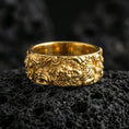 Load image into Gallery viewer, Gold plated guardian lion band ring on volcanic stone, luxury macro shot capturing warm gold tone across the lion head centerpiece and flowing wave motifs.
