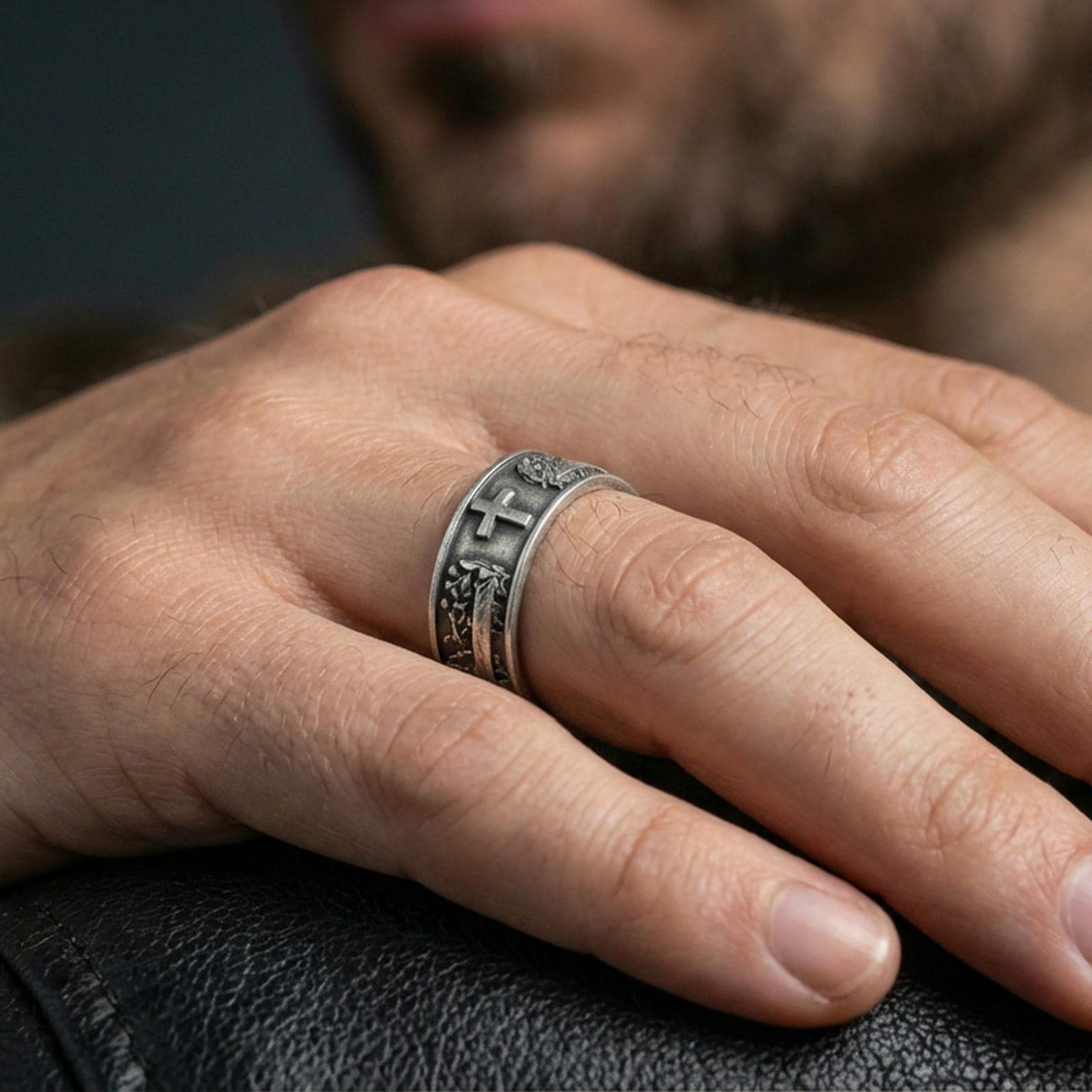 Oxidized sterling silver cross band ring worn on the finger, lifestyle image showing bold contrast, elevated cross centerpiece, and a rugged unisex statement look.