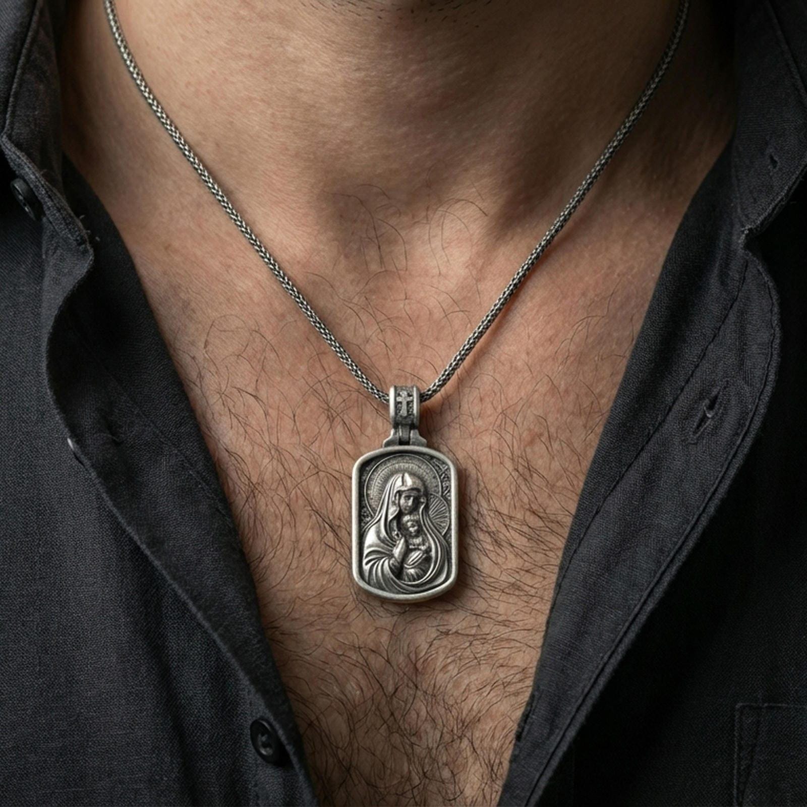 Oxidized Virgin Mary and Baby Jesus pendant worn on the neck in a lifestyle jewelry shot, styled against the chest for a devotional and timeless look