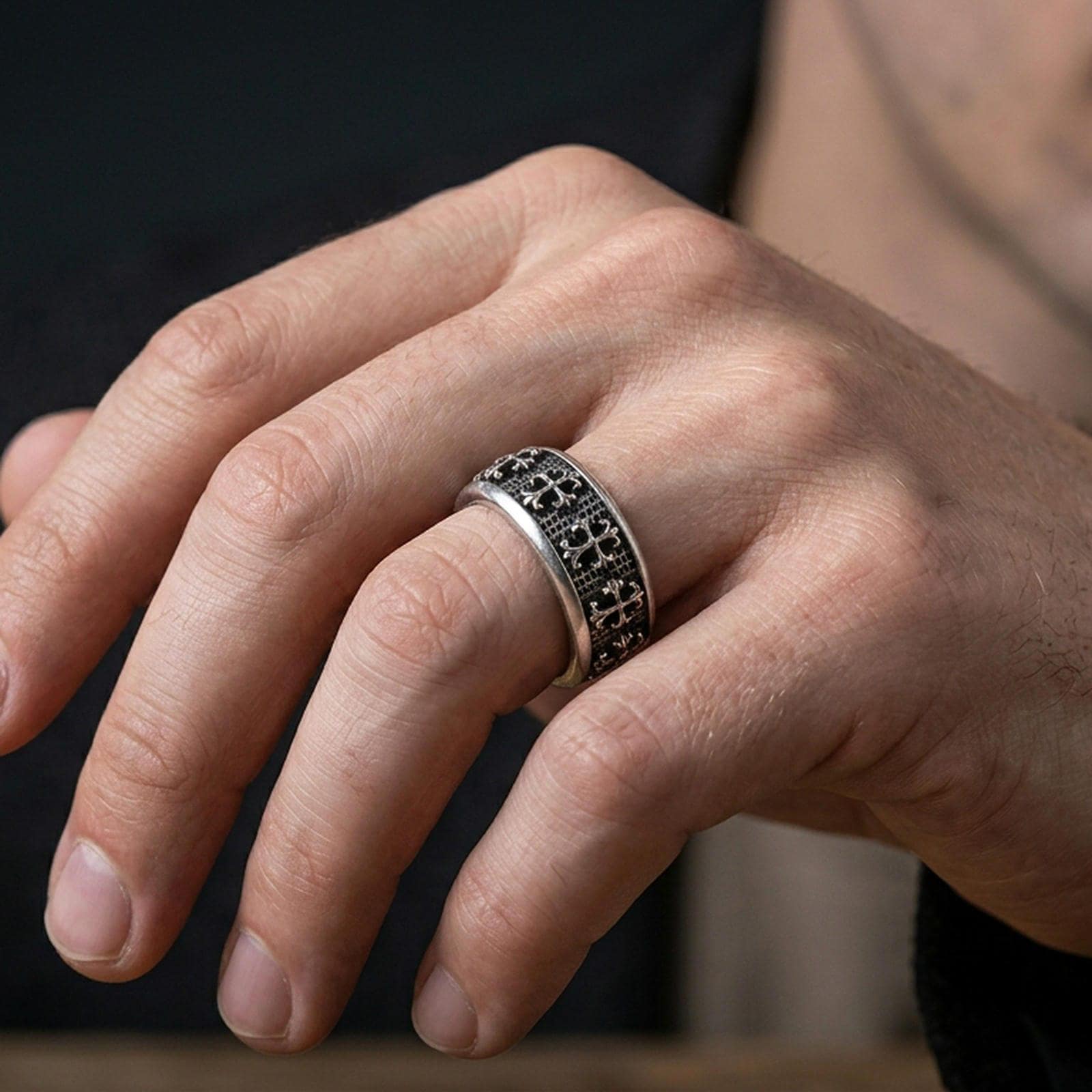 Gothic cross spinner ring worn on a finger, oxidized sterling silver look with bold shadows that make the raised crosses stand out clearly.