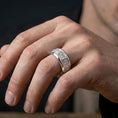 Load image into Gallery viewer, Gothic cross spinner ring worn on a finger, polished silver look with clean highlights that define the spinner band and gothic pattern.
