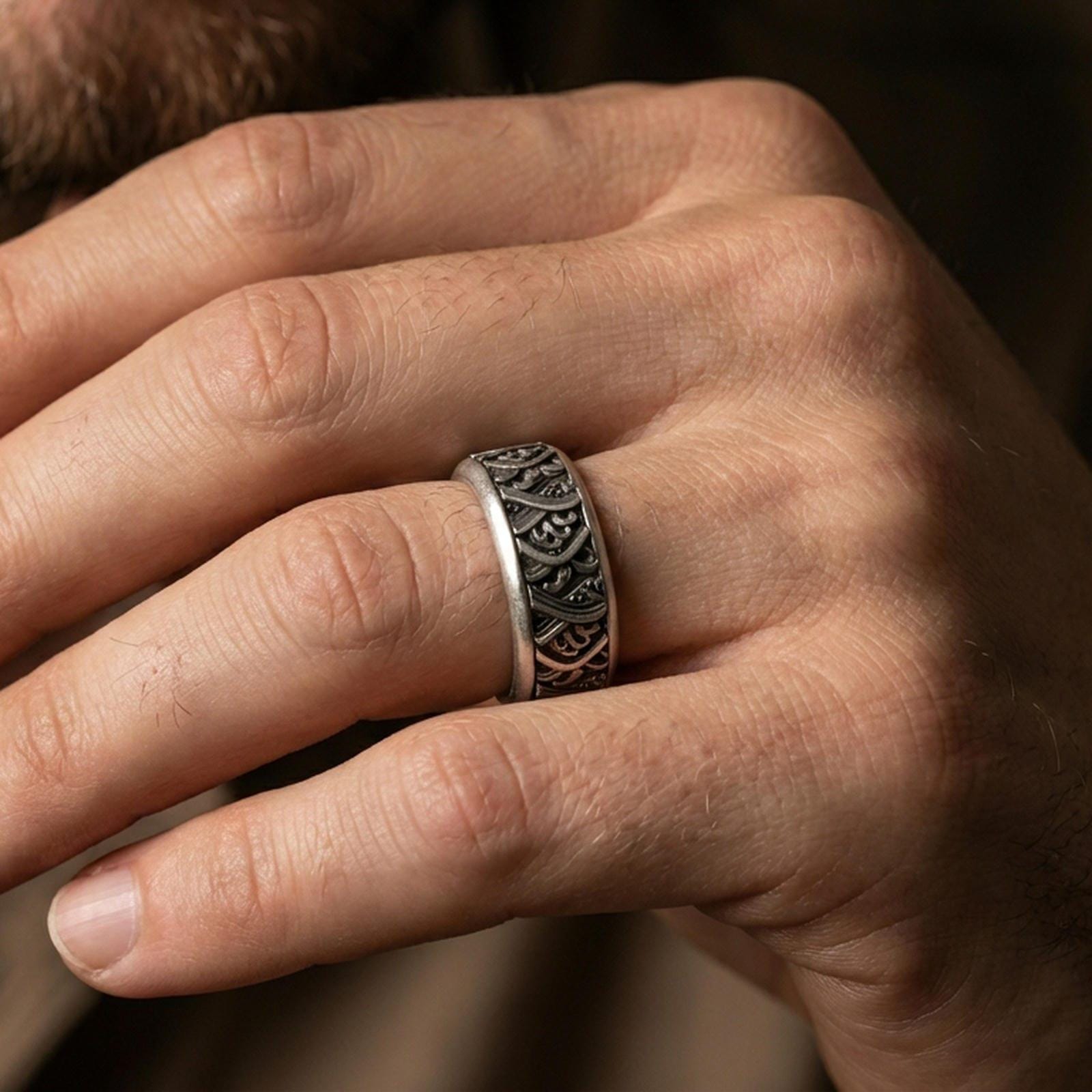 Rotating wave spinner ring worn on a finger, oxidized sterling silver look with strong contrast that makes the wave motif read clearly at a glance.