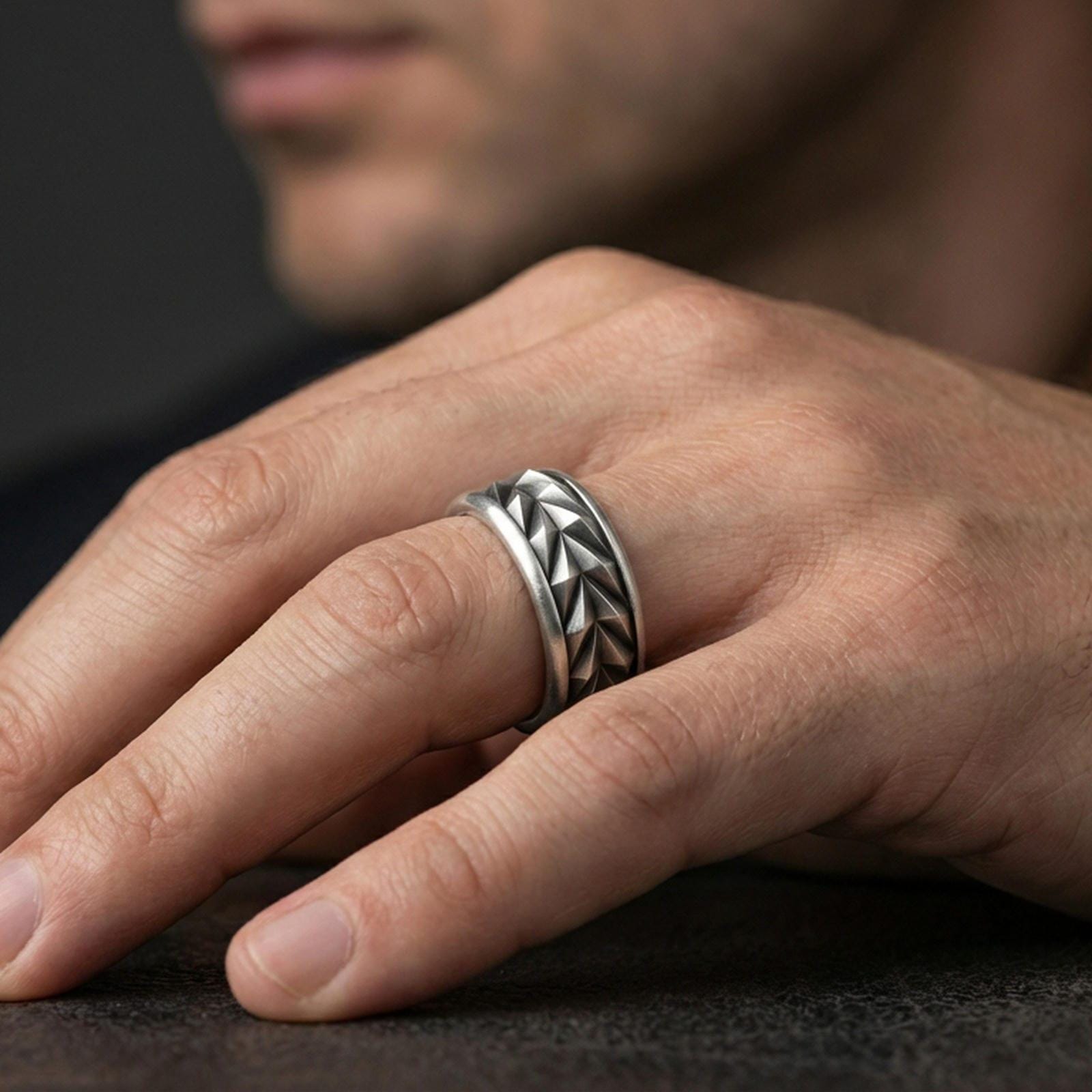 Mechanic style spinning fidget band ring worn on a finger, oxidized sterling silver look with high-contrast detailing that makes the geometric texture stand out.