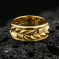 Load image into Gallery viewer, Mechanic style spinning fidget band ring on black volcanic stone, shown in a gold plated finish with warm shine highlighting each angular ridge on the rotating band.
