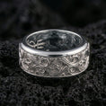 Load image into Gallery viewer, Ornate scrollwork sterling silver band ring on black volcanic stone, photographed in a polished silver look with clean highlights across the flowing vine-like details.
