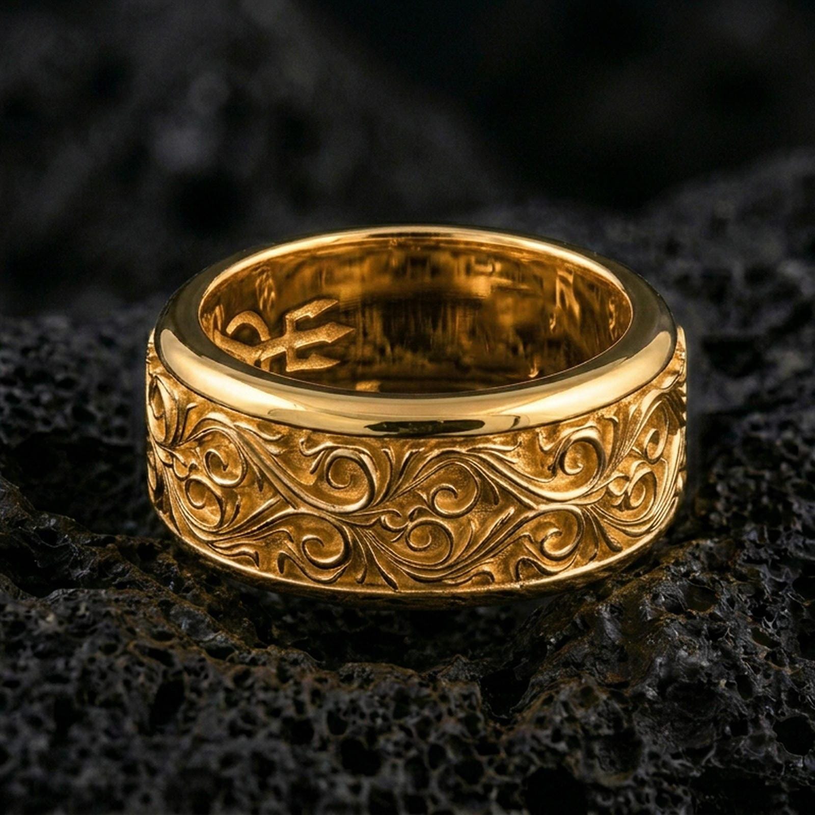 Ornate scrollwork sterling silver band ring on black volcanic stone, shown in a gold plated finish that adds warm shine while keeping the scroll engraving crisp.