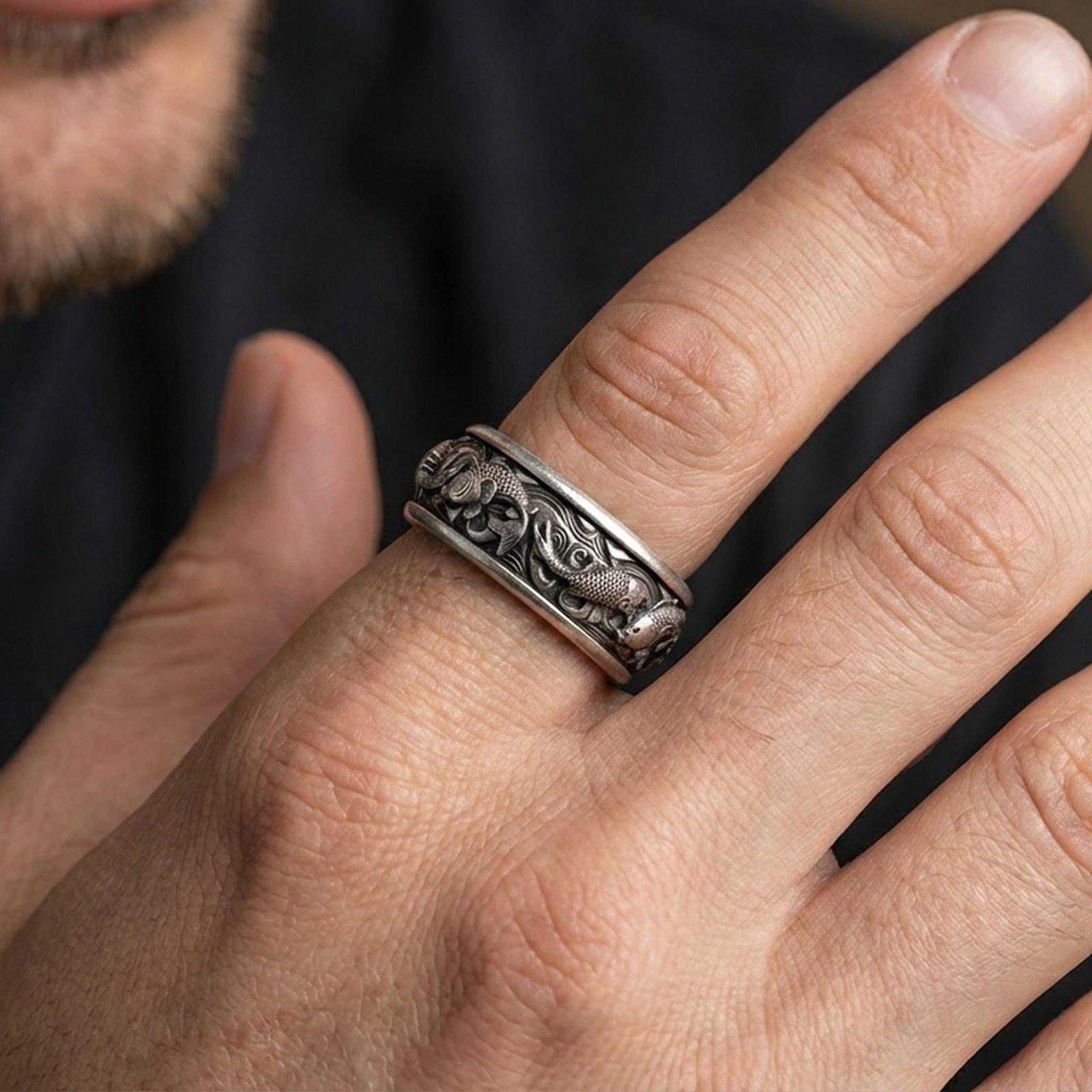 Koi fish sterling silver band ring worn on a finger, oxidized sterling silver look with deep shadows that make the koi and wave pattern pop.
