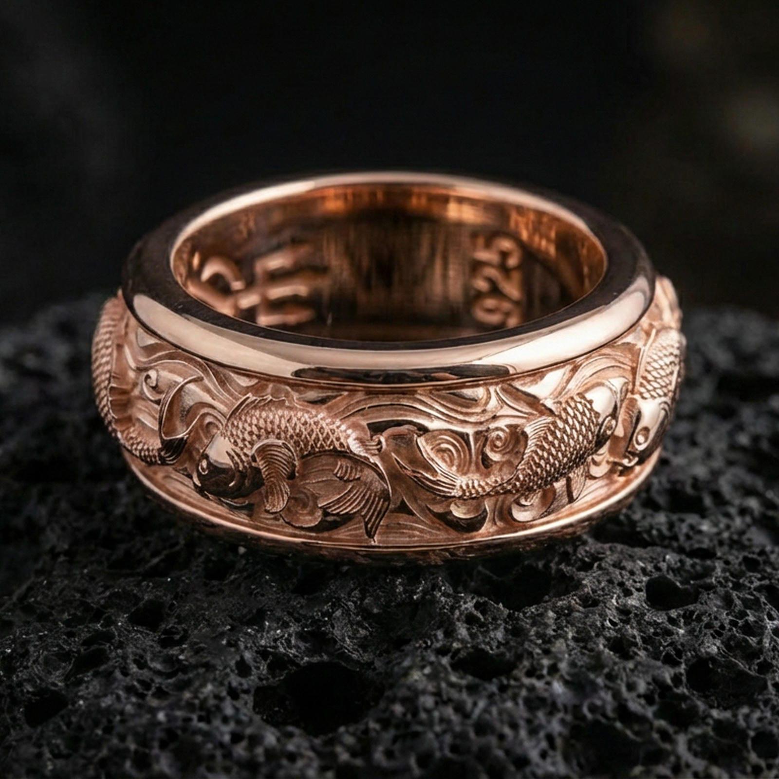 Koi fish sterling silver band ring on black volcanic stone, shown in a rose gold plated finish with a softer warm tone that enhances the koi and wave details.