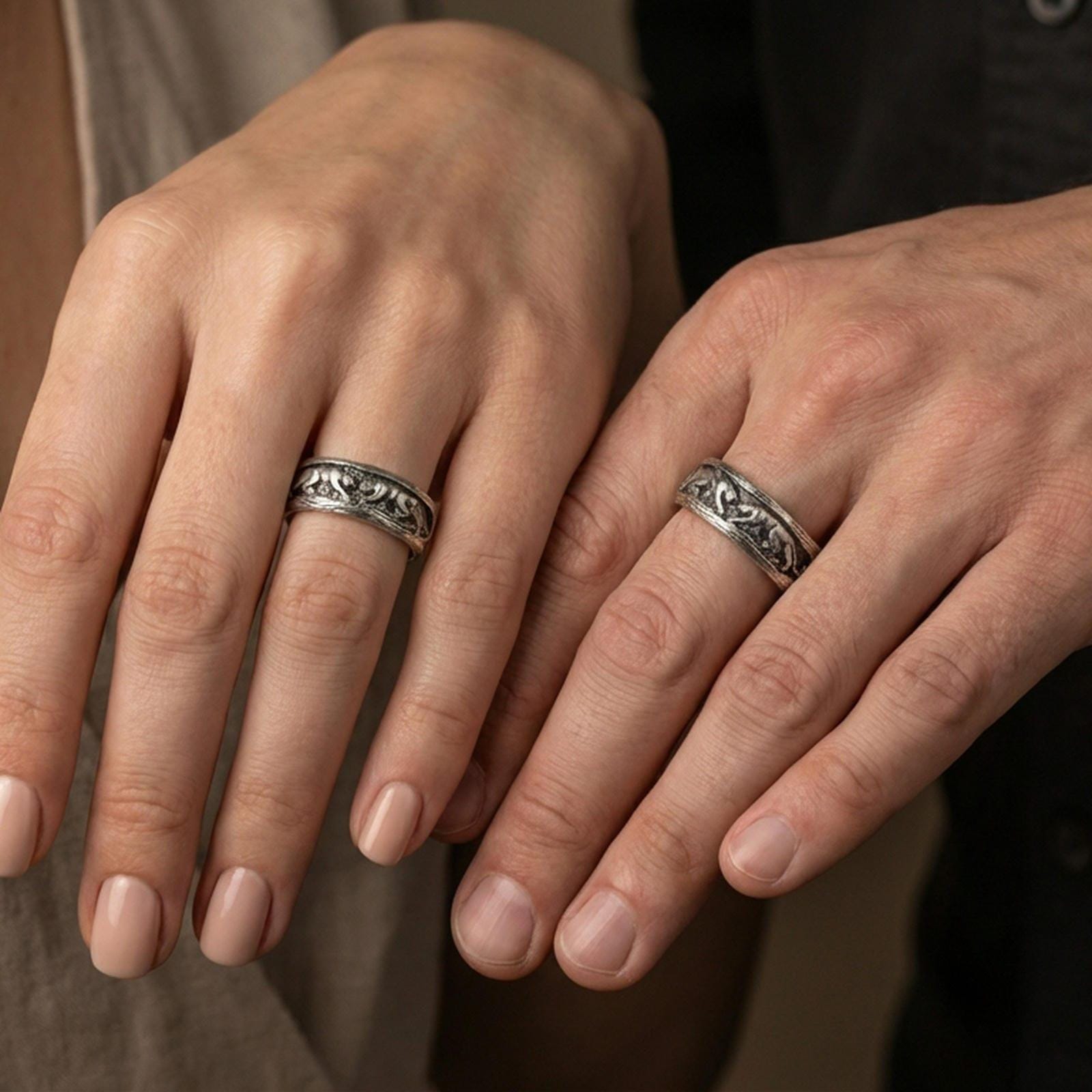 Sterling silver band ring worn on a finger, oxidized finish creating bold contrast that makes the three-monkey relief read clearly at a glance.