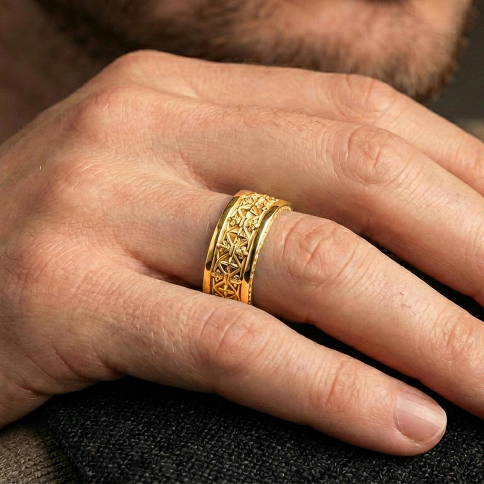 Gothic fleur-de-lis band ring worn on a finger, gold plated finish delivering a bold statement while keeping the pattern sharply defined.