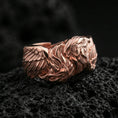 Load image into Gallery viewer, Eagle head and wing sterling silver ring on black volcanic stone, shown in a rose gold plated finish with a soft warm glow over the eagle head details.
