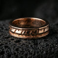 Load image into Gallery viewer, Industrial tread pattern sterling silver spinner ring on black volcanic stone, shown in a rose gold plated finish with a softer warm tone that keeps the tread relief crisp.
