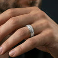 Load image into Gallery viewer, Polished silver engraved wedding band on finger, starburst flower texture detail, refined everyday wear close-up.

