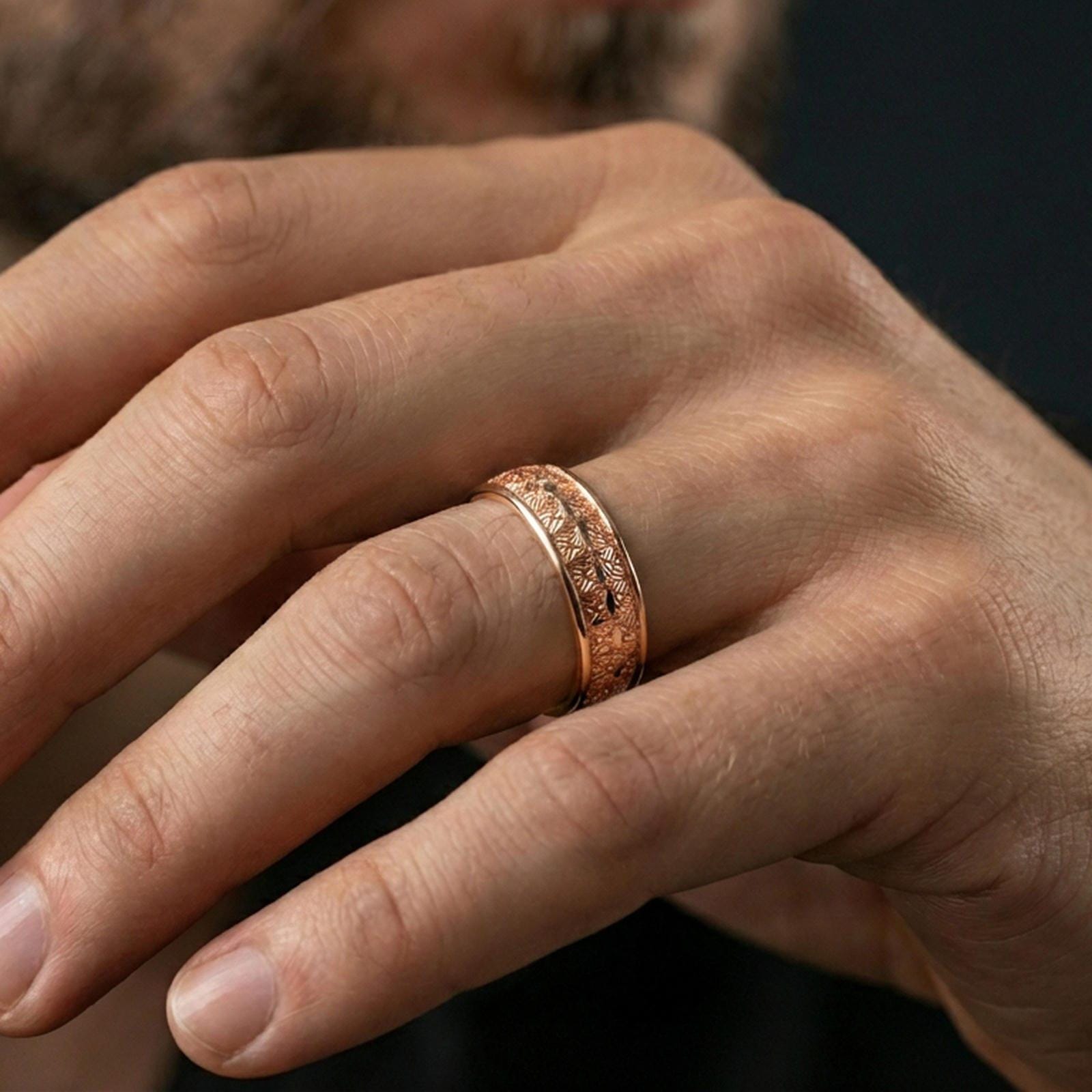 Rose gold plated engraved wedding band on finger, starburst floral texture, elegant lifestyle wear shot with shallow depth of field.