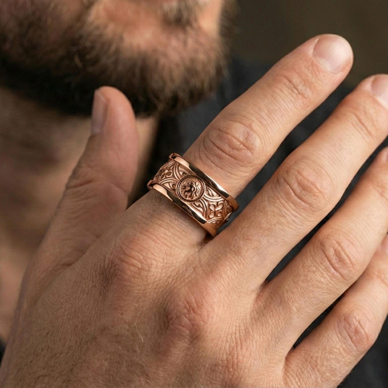 Rose gold plated lion head band ring worn on finger, detailed lion medallion and Gothic pattern engraving, elegant lifestyle wear shot.