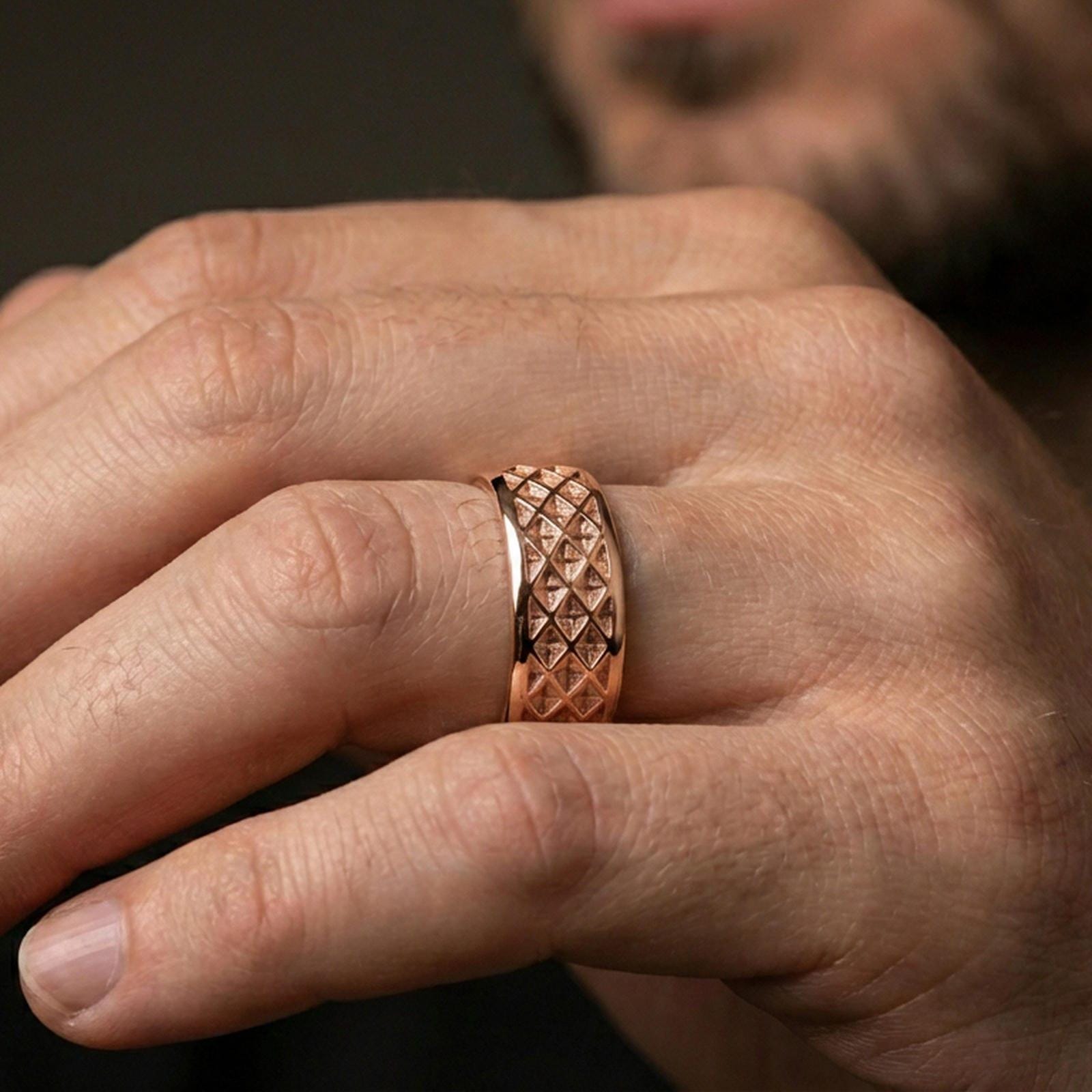 Rose gold plated lattice band ring worn on finger, detailed geometric grid engraving, elegant lifestyle wear shot.