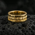 Load image into Gallery viewer, Gold plated serpent skin band ring on volcanic rock, detailed scaled texture with rope edge trim, luxury jewelry product photography.
