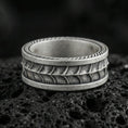 Load image into Gallery viewer, Oxidized sterling silver serpent skin band ring on dark volcanic rock, scaled texture detail with rope edge border, premium macro product shot.
