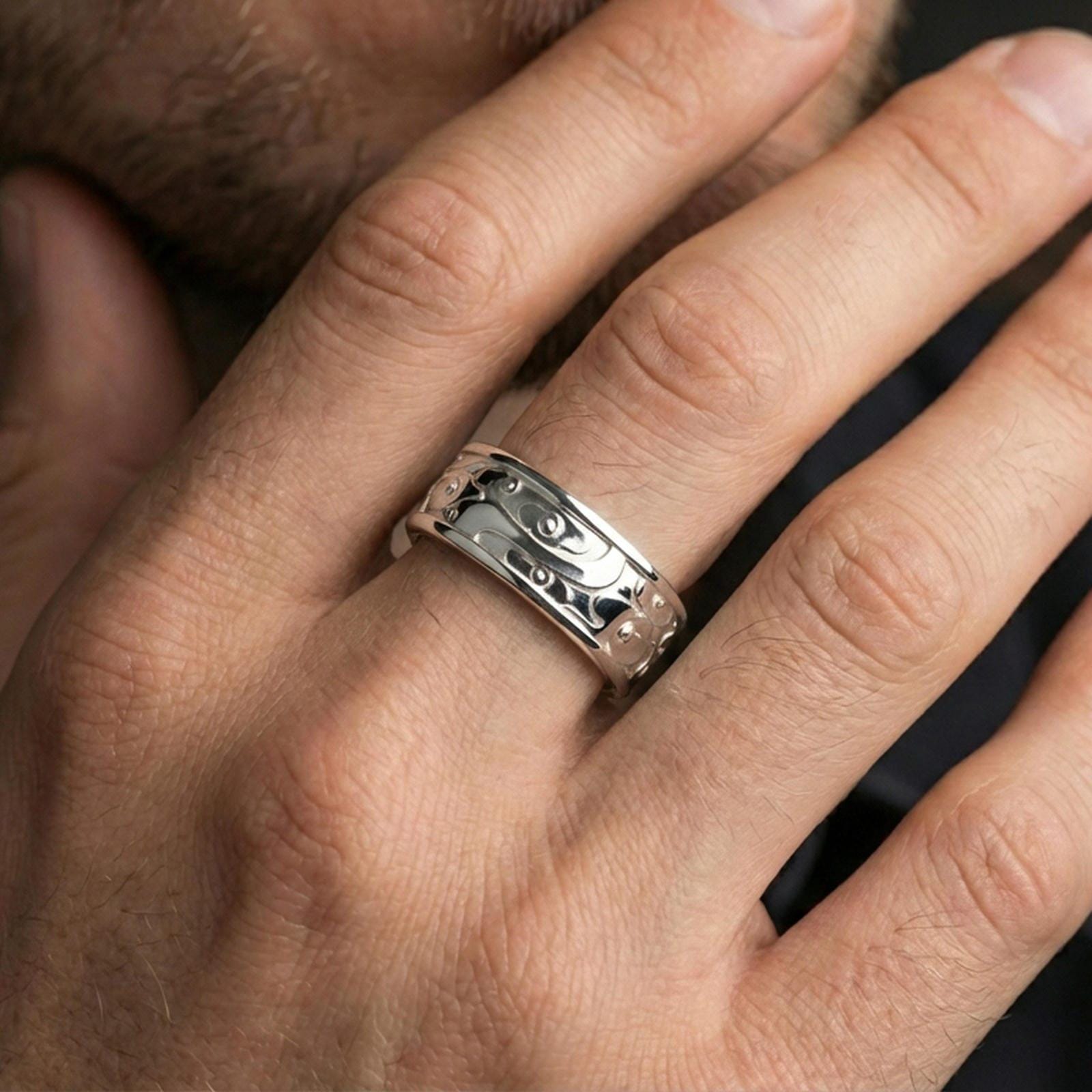 Polished silver fidget spinner cloud and flower band ring on finger, crisp swirl relief and smooth edges, refined everyday wear close-up.