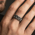 Load image into Gallery viewer, Oxidized sterling silver Cuban link ring worn on finger, engraved chain link detail, natural lifestyle hand shot with shallow depth of field.
