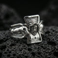 Load image into Gallery viewer, Polished silver Jesus crucifix ring on black volcanic stone, crisp sculpted Christ figure and angular cross outline, centered close-up studio lighting.
