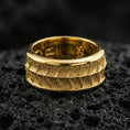 Load image into Gallery viewer, Gold plated lizard scale spinner band ring on volcanic rock, detailed reptile pattern on rotating band, luxury jewelry product photography.
