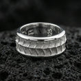Load image into Gallery viewer, Polished silver lizard scale fidget spinner ring on black volcanic stone, crisp reptile texture detail with smooth comfort edges, centered close-up studio lighting.
