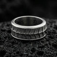 Load image into Gallery viewer, Oxidized sterling silver lizard scale spinner band ring on dark volcanic rock, textured reptile pattern on rotating center, premium macro product shot.
