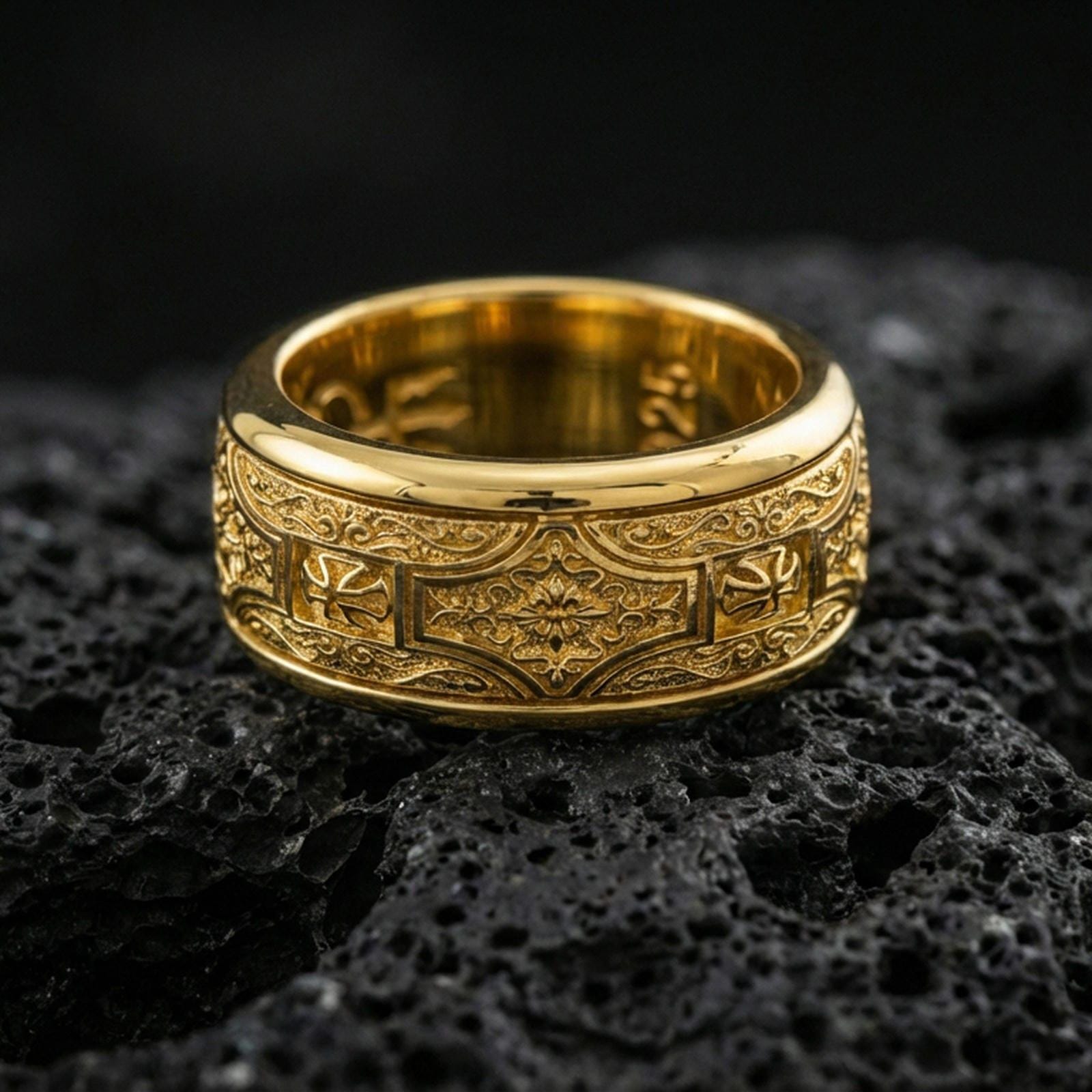 Gold plated ornate filigree band ring on volcanic rock, detailed floral centerpiece with vintage scroll engraving, luxury jewelry product photography.