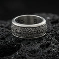 Load image into Gallery viewer, Oxidized sterling silver ornate filigree band ring on dark volcanic rock, vintage floral centerpiece and scroll engraving, premium macro product shot.
