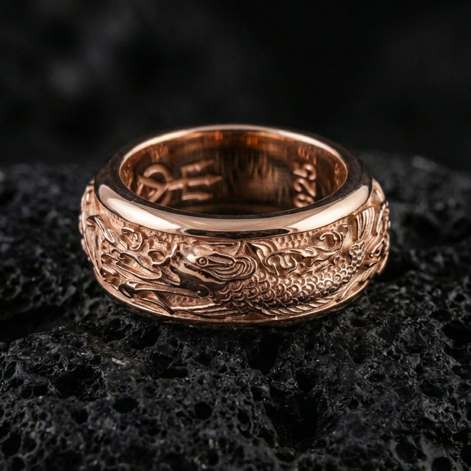 Rose gold plated sterling silver koi fish spinner ring on volcanic stone, sculpted koi and wave relief with deep contrast, minimal high-end close-up.