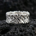 Load image into Gallery viewer, Polished silver twisted rope band ring on black volcanic stone, crisp spiral cable texture with sculpted grooves, centered close-up studio lighting.
