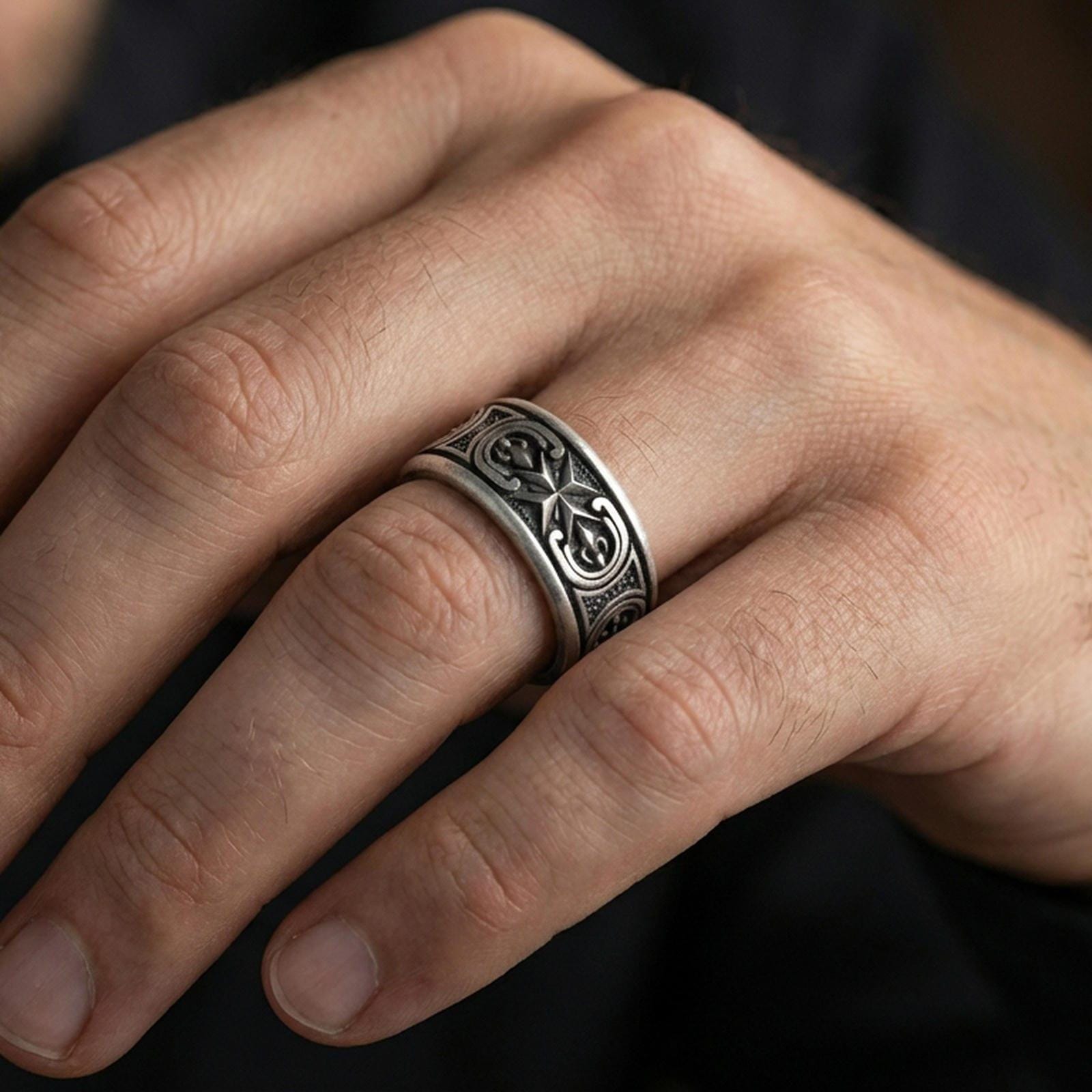 Oxidized sterling silver Maltese cross spinner band worn on finger, raised cross motif detail on rotating center, natural lifestyle hand shot with shallow depth of field.