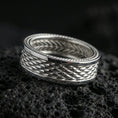 Load image into Gallery viewer, Polished silver braided rope band ring on black volcanic stone, crisp woven texture with beaded border accents, centered close-up studio lighting.
