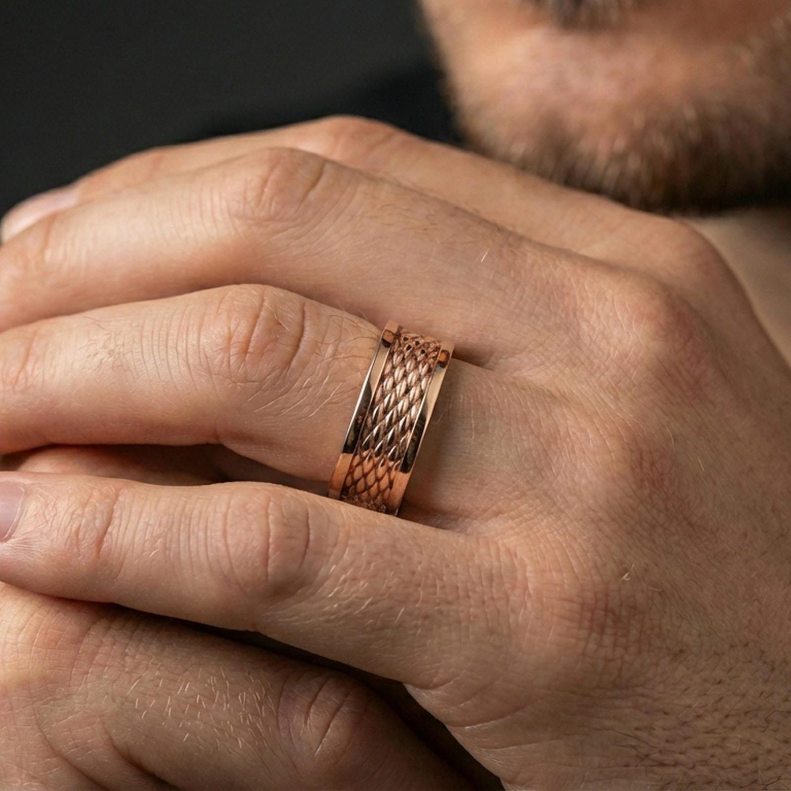 Rose gold plated braided rope band ring worn on finger, sculpted woven texture detail with dotted edges, elegant lifestyle wear shot.