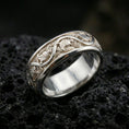 Load image into Gallery viewer, Polished silver dove engraved band ring on black volcanic stone, crisp pigeon motif and flowing vine details, centered close-up studio lighting.
