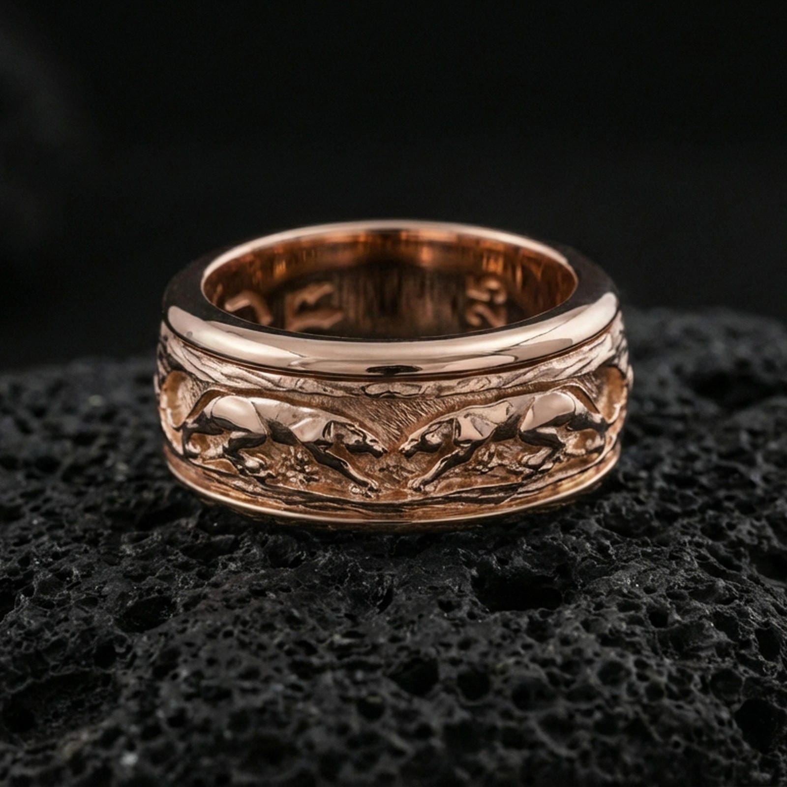 Rose gold plated sterling silver jaguar spinner ring on volcanic stone, sculpted big cat relief with deep contrast and smooth edges, minimal high-end close-up.