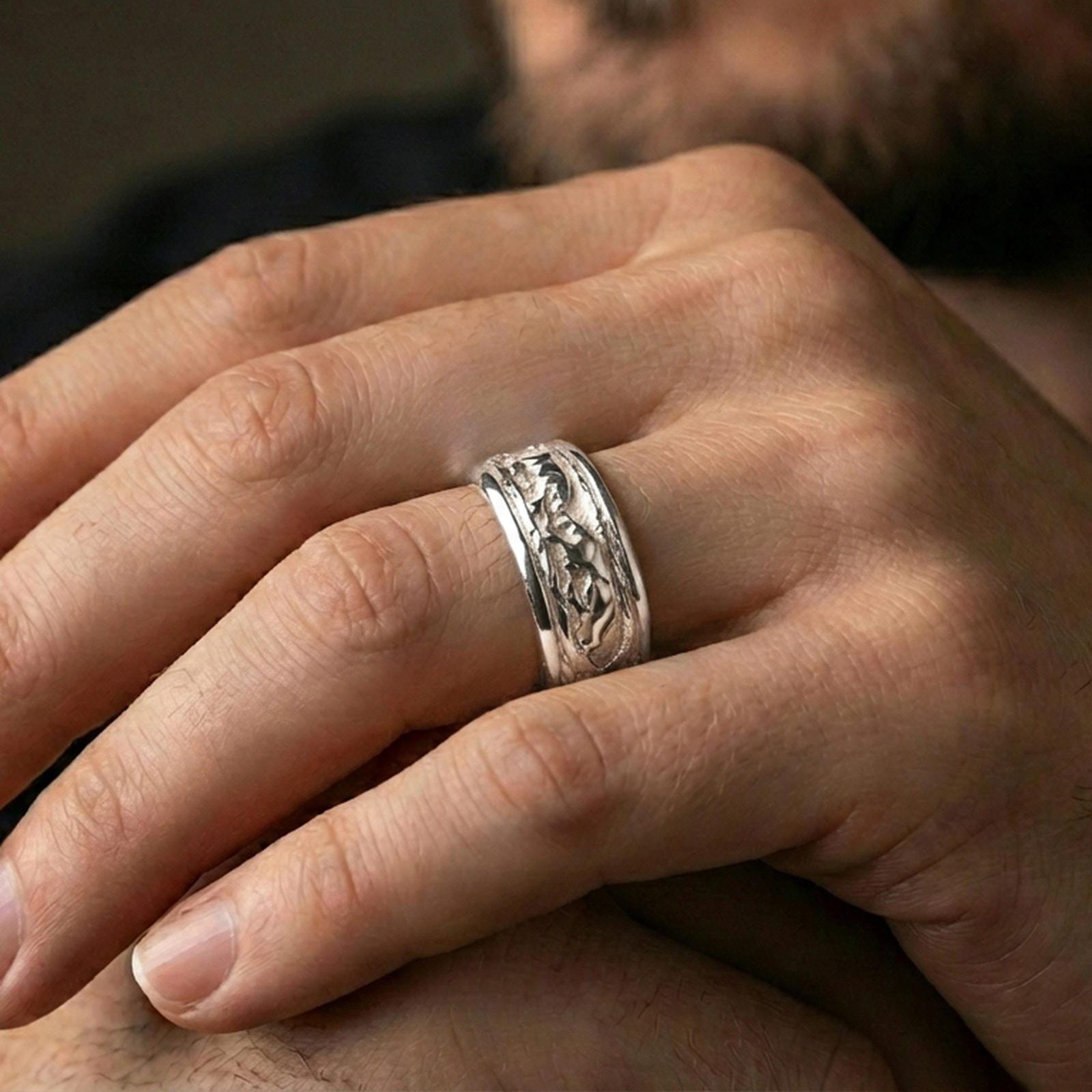 Polished silver jaguar fidget spinner ring on finger, crisp big cat relief scene on rotating band, refined everyday wear close-up.