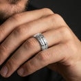 Load image into Gallery viewer, Polished silver arrowhead fidget spinner ring on finger, crisp repeating arrow motif and smooth edges, refined everyday wear close-up.
