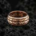 Load image into Gallery viewer, Rose gold plated sterling silver arrowhead spinner ring on volcanic stone, bold geometric arrow relief with deep contrast, minimal high-end close-up.
