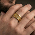 Load image into Gallery viewer, Gold plated jungle wildlife band worn on finger, detailed tropical foliage relief with wildlife engraving, premium lifestyle jewelry photo.
